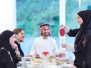 Muslim family having Iftar dinner drinking water to break feast