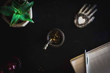 Vista superior de una bebida mate con un termo verde, un adorno hindú en forma de corazón, un...