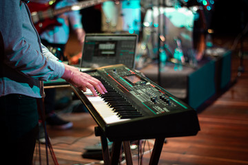 hands of a man playing the piano