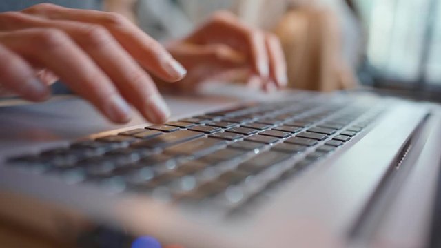Businesswoman using laptop- close-up. Close-up of female fingers typing laptop keyboard. young woman using laptop at office
