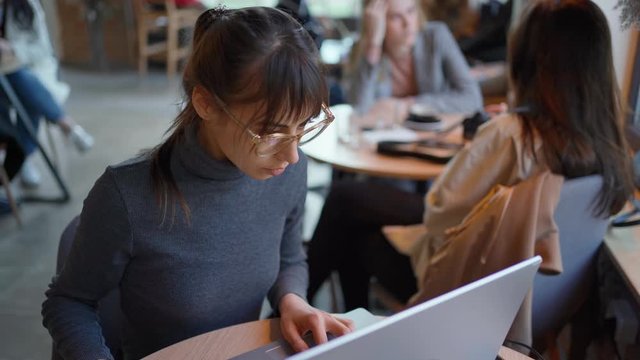 attractive woman entrepreneur working by laptop in cafe or coworking. freelance, remote work, self employed