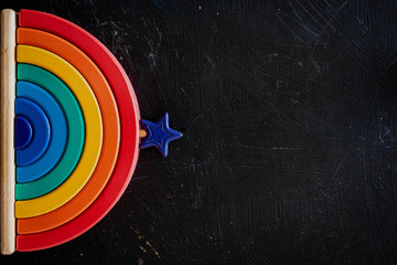 Arco iris de madera en un escritorio de madera negra  © Maximiliano Ramos