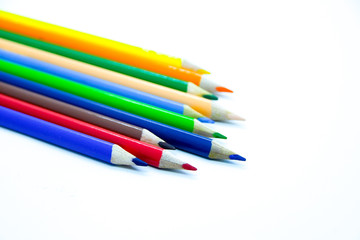 Photo of arrangement of color pencils isolated on white background. Blank space for text. Flat lay. Close up. Top view. Leadership business concept. School concept. Rainbow color pencil.