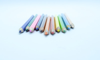Photo of arrangement of color pencils isolated on white background. Blank space for text. Flat lay. Close up. Top view. Leadership business concept. School concept. Rainbow color pencil.