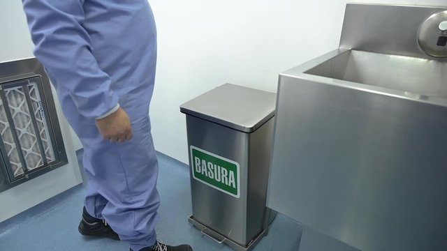 Persona tirando basura material contaminado en contenedores especiales