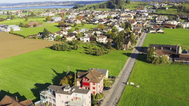 Aerial view of European town and field, vehicles dring on roads