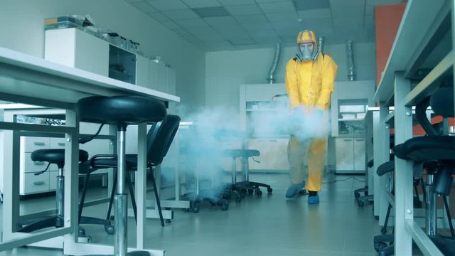 Sanitation worker sprays laboratory room. Covid19, coronavirus concept.