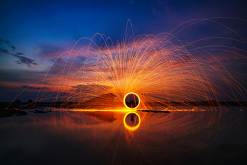 spinning burning steel wool in the River sunset,