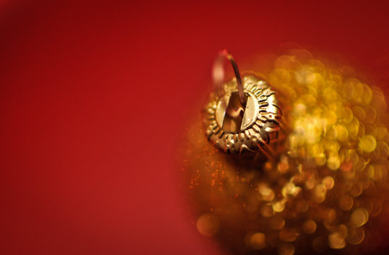 Close Up Of Christmas Bauble Against Red Background