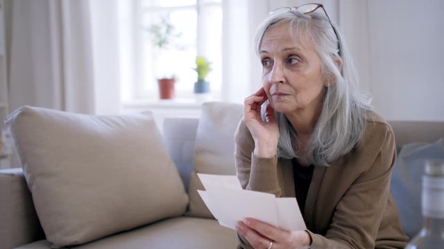 Depressed woman looking at photographs indoors, mental health concept.