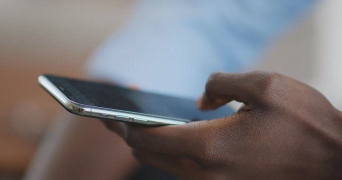 Black male hands using modern mobile phone