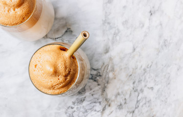 Iced frothy Dalgona Coffee, a trendy fluffy creamy whipped coffee. Korean drink latte espresso with coffee foam. made of instant coffee, sugar, hot water and milk.