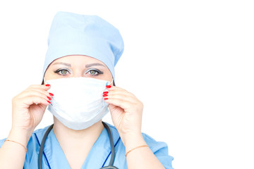 Close-up of a female doctor putting on a medical mask while looking at the camera.