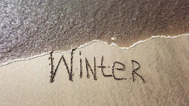Winter inscription on the shore of the ocean