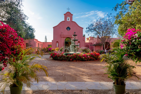 Ancient church with a fountain adorned with flowers on a sunny day at the Tacama hacienda, Ica Peru Hacienda Tacama