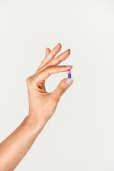 Pharmaceutical pill in a feminine hand