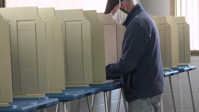 One person wearing protective mask voting alone