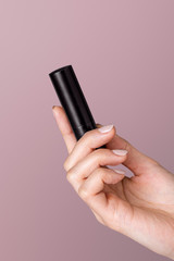 Black lipstick case in a feminine hand
