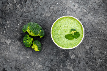 Broccoli vegan cream soup in bowl on grey table from above