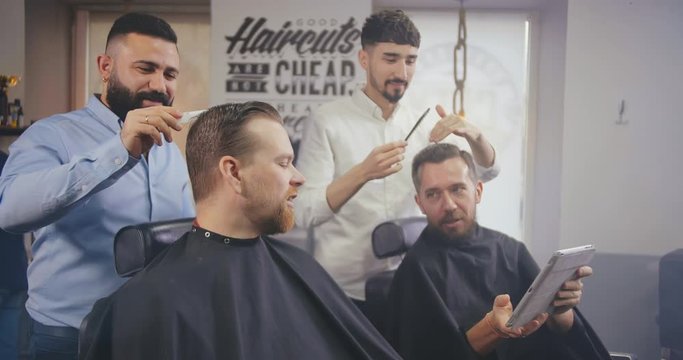 Clients communicating in barber shop during haircut