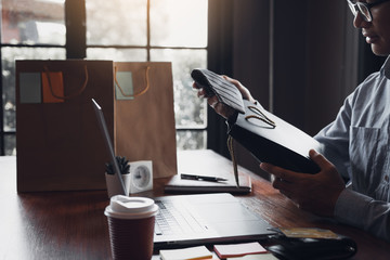 Man holding a gift bag with a necktie inside out as a gift at the cafe.