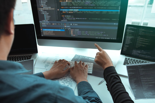 Developing programming and coding technologies working in a software engineers developing applications together in office.