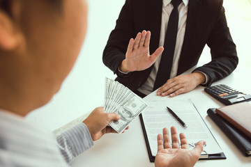 Business person refusing bribe given money by partner with anti bribery corruption concept.