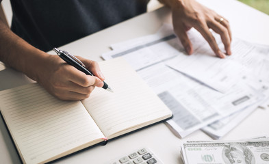 Man use calculators and documents that calculate expenses in the home office.