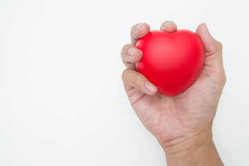 The hand is holding Heart shaped squeeze ball for hand muscle exercise on white background  and copy space