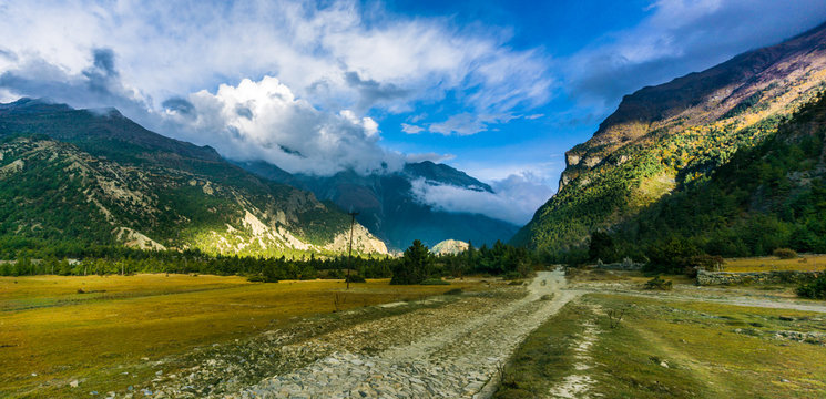 Panoramic view of trekking trail and mountain road with clouds in the Annapurna Circuit near Humde, Manang, Nepal