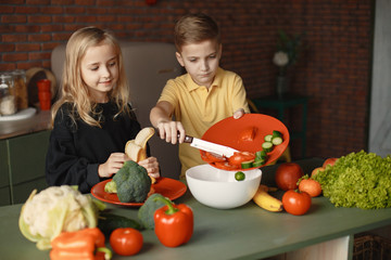 Brother and sister. Children prepare the salad. Kids in the kitchen.