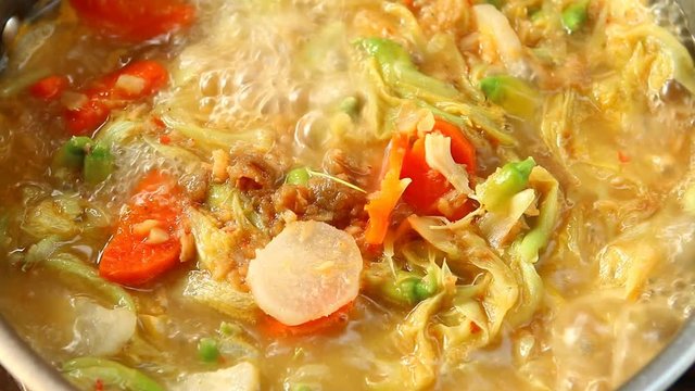 Cooking tamarind sour soup with agasta or Kang som , Thai famous food