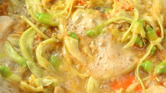 Cooking tamarind sour soup with agasta or Kang som , Thai famous food
