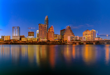 Downtown view across Lady Bird Lake or Town Lake on Colorado River at sunset golden hour in Austin, Texas, USA