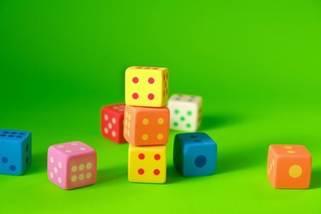 Cube with numbers.Bouncing dice. Multicolored cubes set on a  green background. Numbers and symbols. Figure 4. Board game. Chaos. The same amount. Luck and luck.