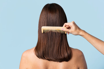 Hairstylist combing a woman's hair