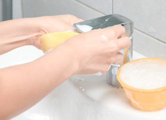 Person or householder cleaning the bathroom sink