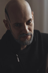 Man in sweater shaved bald head, white beard