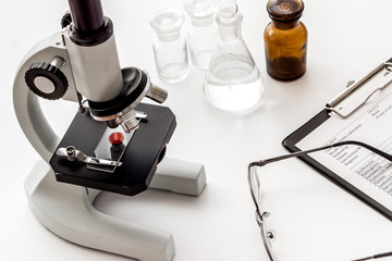 Research with microscope. Laboratory backround with blood sample on white table
