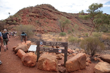 Tourists hiking with hiking sign in Kings Canyon outback central Australia