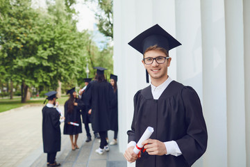 A young male graduate with a scroll of university