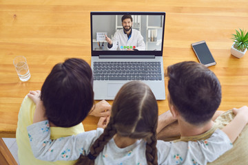 Family doctor online.Parents and a child consult a doctor using a laptop at home.