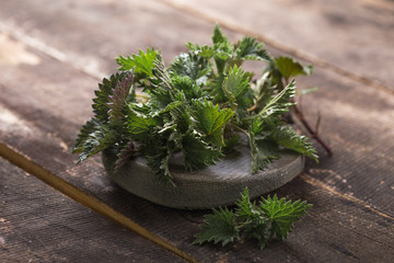 Fresh stinging nettle leaves on wooden table.Urtica dioica