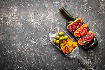 Wine appetizer on bottles as dinnerware on grey table top view copy space
