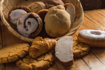Bread basket, typical of the peoples of Mexico, with sweet bread such as conchas, rebanadas, cuernitos, cinnamon rolls, polvorones, on a wooden table.
Something excessively typical in Mexico. 2