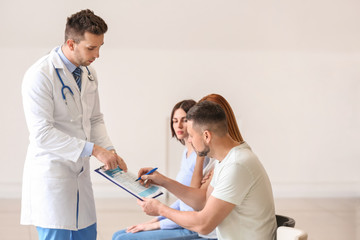 Obraz premium Male doctor with patients in hall of clinic