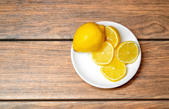 Limón Amarillo Con Cortes De Limon En Un Plato De Ceramica Blanca Vista Desde Arriba Sobre Una Madera