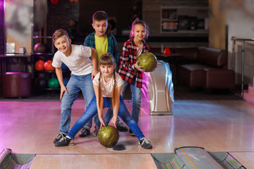 Fototapeta premium Little children playing bowling in club