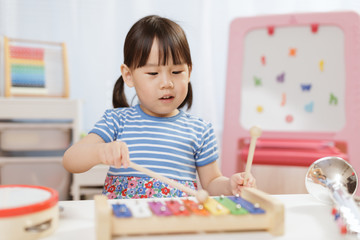 Obraz na płótnie Canvas toddler girl play xylophone at home for homeschooling