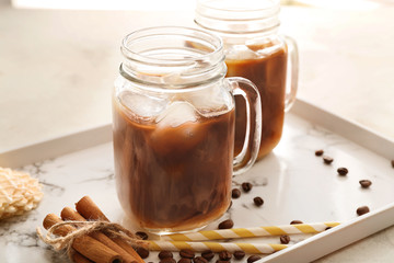 Mason jars of tasty cold coffee on tray